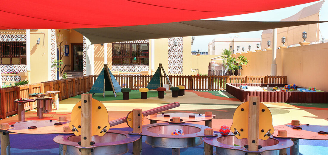 The shaded outdoor play area at Treehouse Nursery with water play tables