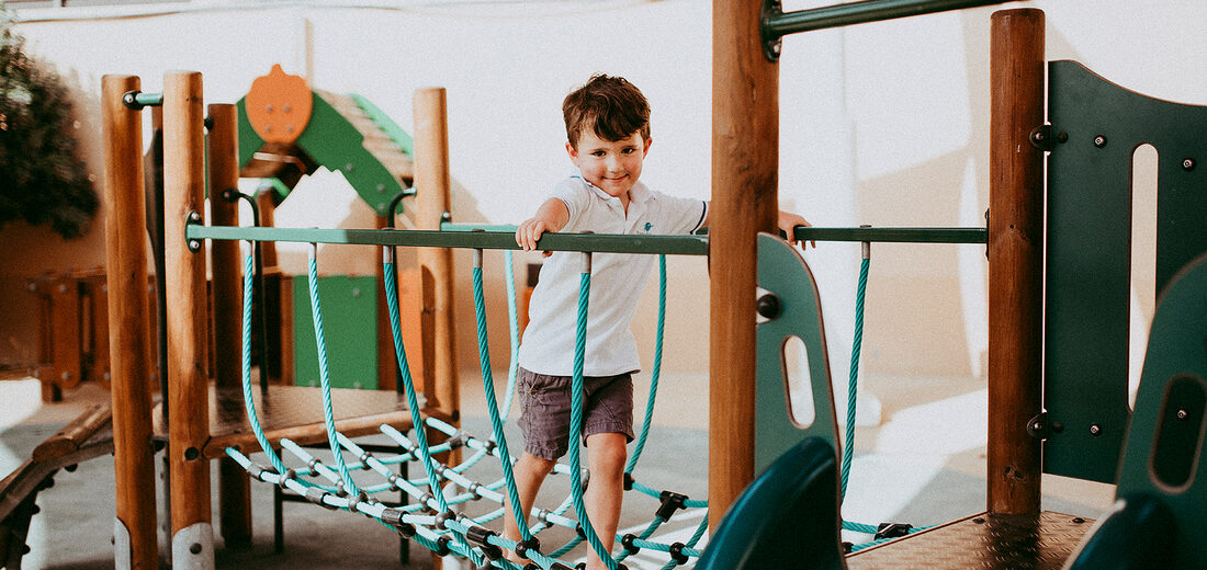 A child climbing on the outdoor play frame at Treehouse Nursery